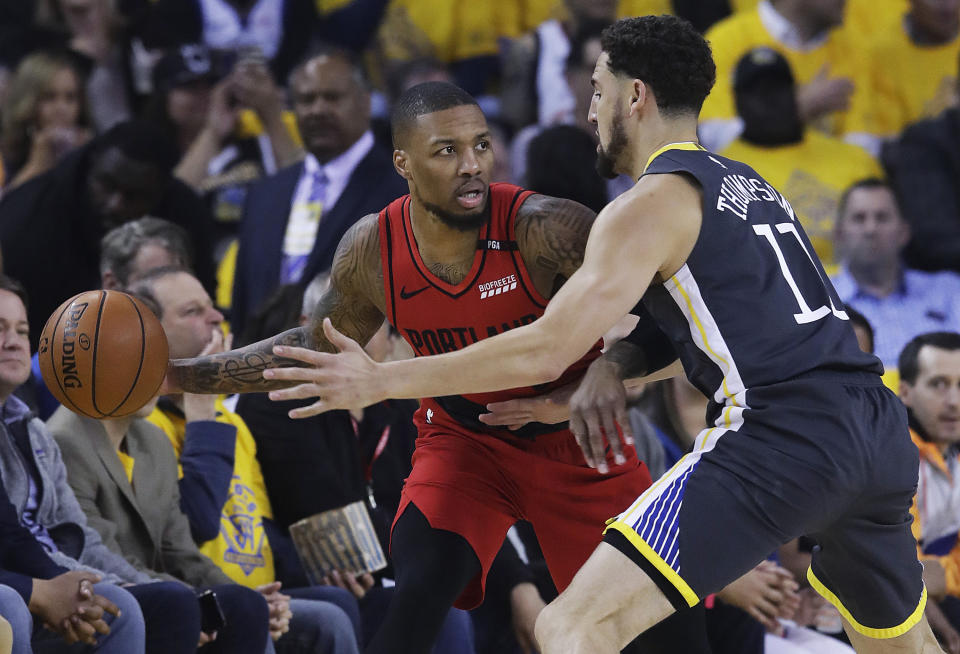 Portland Trail Blazers guard Damian Lillard, left, is defended by Golden State Warriors guard Klay Thompson during the first half of Game 2 of the NBA basketball playoffs Western Conference finals in Oakland, Calif., Thursday, May 16, 2019. (AP Photo/Jeff Chiu)