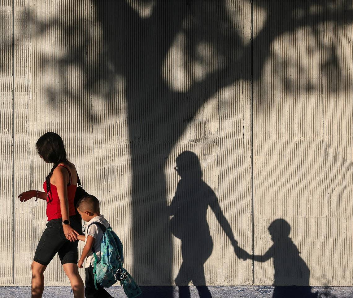 Yeiny Gonzalez walks with her son Ryland, who is beginning kindergarten on Wednesday at Miami Gardens Elementary School in Miami Gardens, Florida.