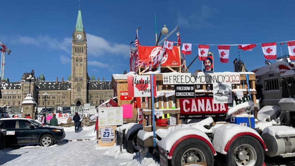 Freedom Convoy Demonstration in Ottawa.before police moved in on 20 Feb 2022. See truck and protest signs in front of Parliament buildings.