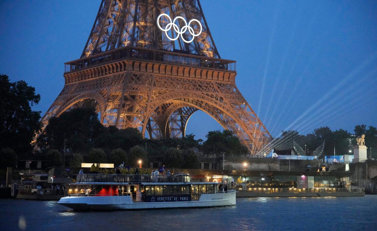 Athletes make their way down the Seine, past the Eiffel Tower, during the opening ceremony.