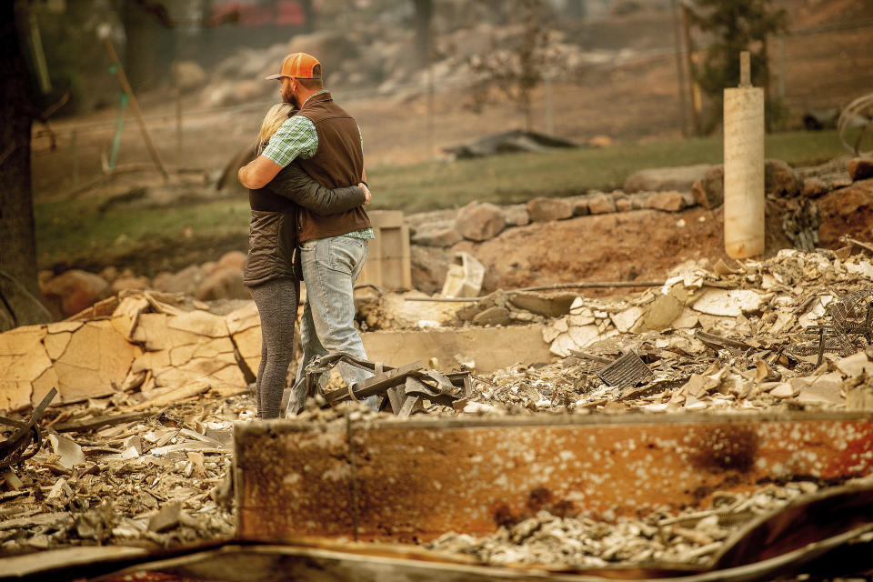 Chris and Nancy Brown embrace while searching through the remains of their home, leveled by the Camp Fire, in Paradise, Calif., in November. (Photo: Noah Berger/AP)