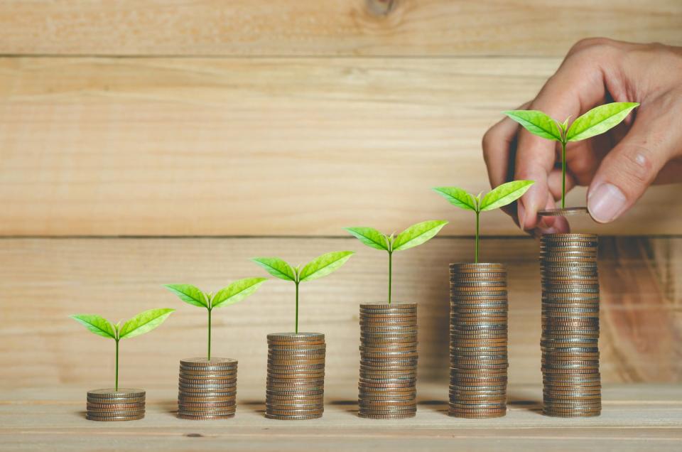 Six rising stacks of coins, each with a sprouted leaf. 