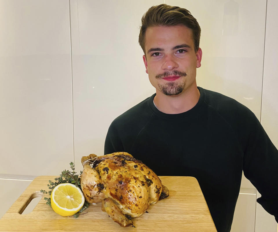 This undated photo taken by TK, shows Harry Heal holding a roasted chicken. Heal, a 26-year-old who lives in Dubai, is one of the burgeoning celebrity chefs on TikTok. He has garnered about a million followers in the six months he’s been posting cooking videos. (TK via AP)