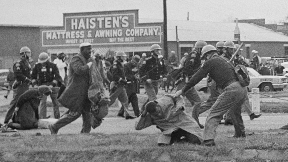 In this March 7, 1965 file photo, an Alabama state trooper swings a billy club at John Lewis (right foreground), chairman of the Student Nonviolent Coordinating Committee, to break up a voting rights march in Selma, Alabama. Lewis went on to continue efforts against voter suppression as a U.S. congressman. (Photo: AP/File)