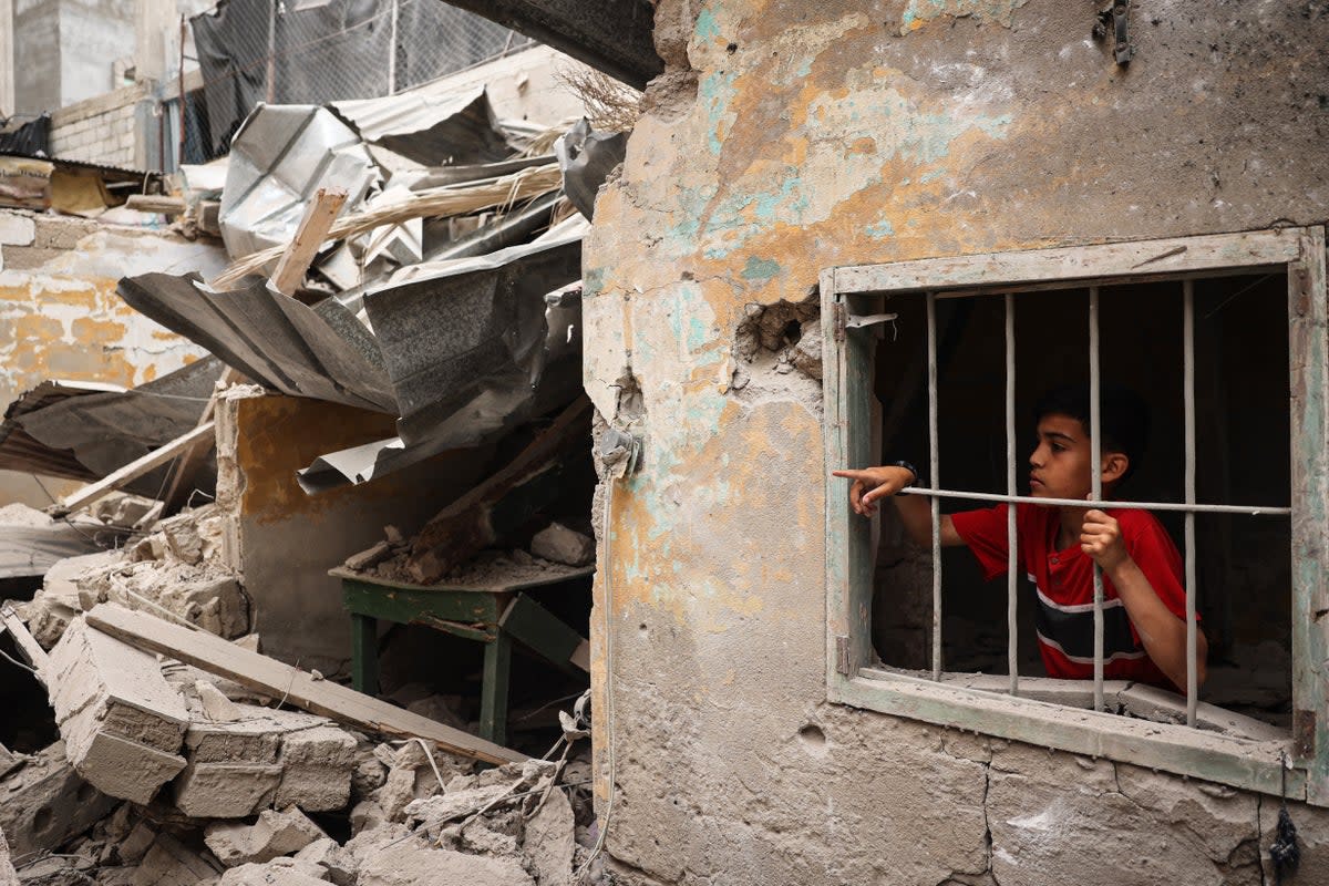 A Palestinian child looks out from the debris of a house destroyed by overnight Israeli bombardment in Rafah (AFP/Getty)