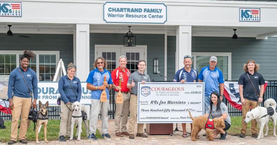 Foar from Home, a four-man rowing team, presents K9s for Warriors officials with the $350,000 proceeds from their charity row across the Atlantic.