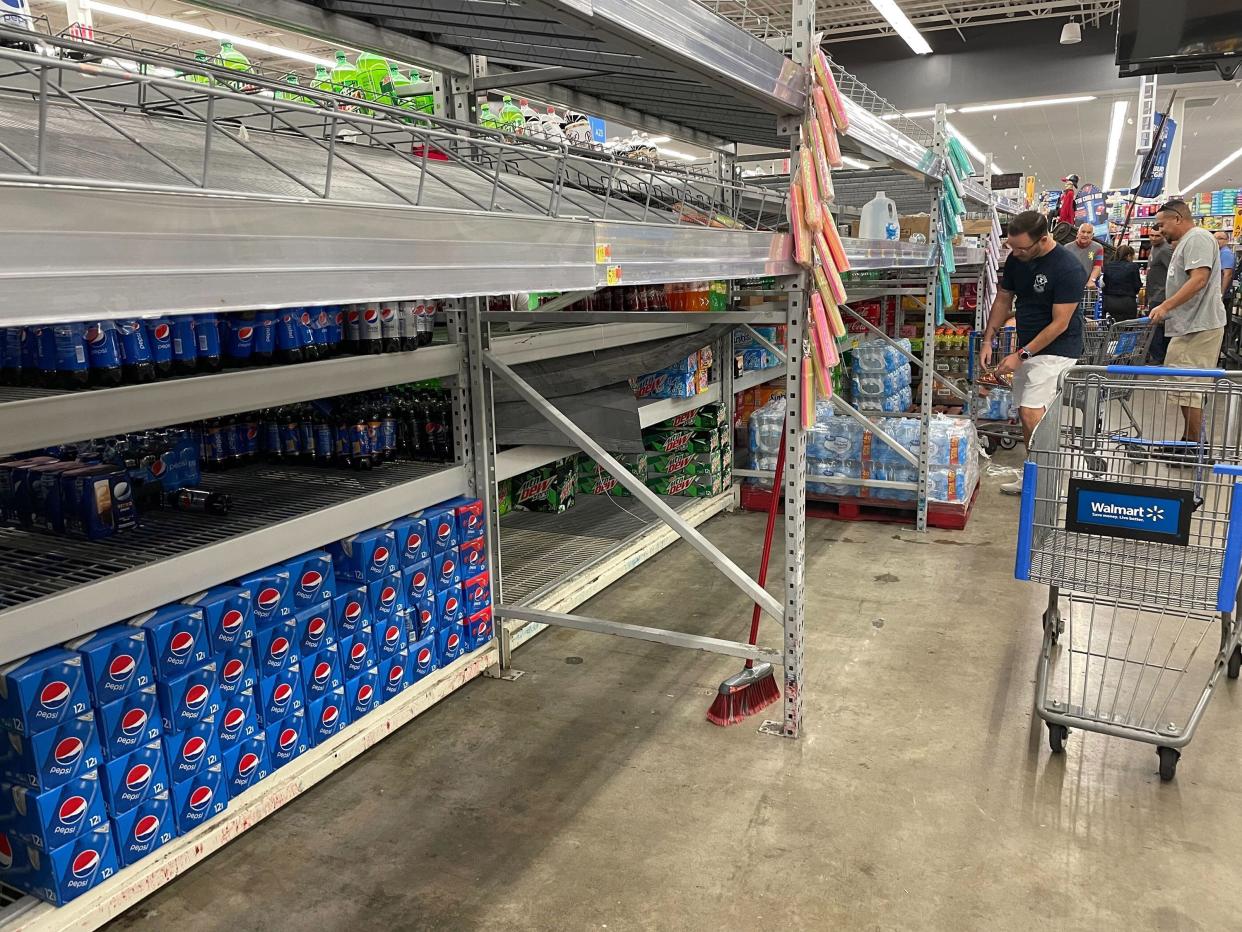 Shoppers go for what was left of the water on the shelves of the Walmart Supercenter at 1505 N. Dale Mabry Highway on Sunday, Sept. 25, 2022, in Tampa, Fla. as Tropical Storm Ian threatens to impact Tampa Bay as a major hurricane later in the week.