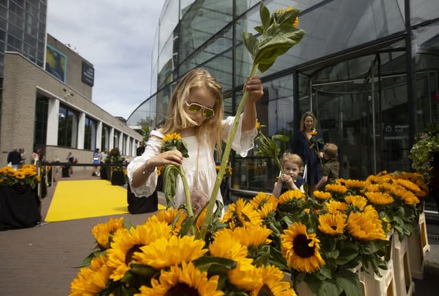 Visitors leaving the reopened Van Gogh were offered a free sunflower in Amsterdam (Peter Dejong/AP)