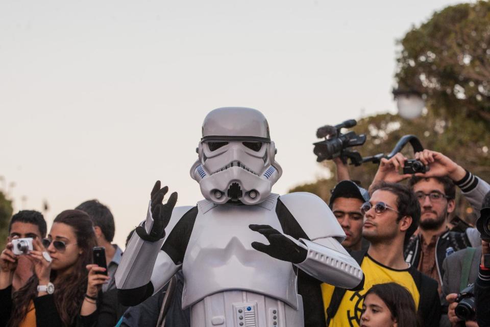 A Star Wars fan wearing a stormtrooper costume parades along Tunis’ stately, tree-lined Bourguiba Avenue, in Tunisia, Wednesday, April 30, 2014. The empire was not striking back against the poster child for Arab democracy — just an innovative campaign to encourage tourists to return to this sunny desert-and-beach nation in North Africa. "We came here to Tunis to help save the Star Wars sites in Matmata and Tozeur and convince people to return to Tunisia," said Ingo Kaiser, head of a Star Wars fan club in Europe, referring to the movie sets that are slowly being covered up by sand in the Tunisian desert. (AP Photo/Aimen Zine)