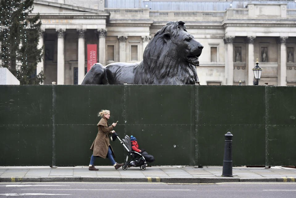 Fencing around the lion statues in Trafalgar Square, London, ahead of New Year's Eve celebrations, Thursday Dec. 31, 2020. The British government has extended its toughest coronavirus restrictions to more than three-quarters of England’s population, saying a fast-spreading variant of the virus has reached most of the country. The move will severely curtail New Year’s Eve celebrations in parts of England that are home to 44 million people, or 78% of the population. People are advised to stay home, nonessential shops are shut and restaurants and bars can only offer takeout. (Dominic Lipinski/PA via AP)