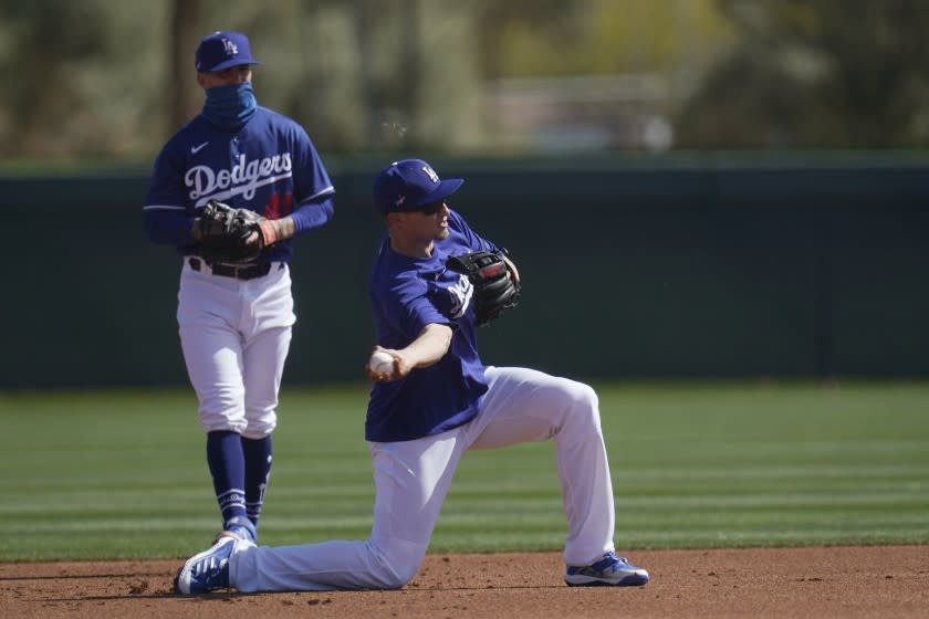 Los Angeles Dodgers shortstop Corey Seager, right, throws to second base as Dodgers infielder Omar Estevez.