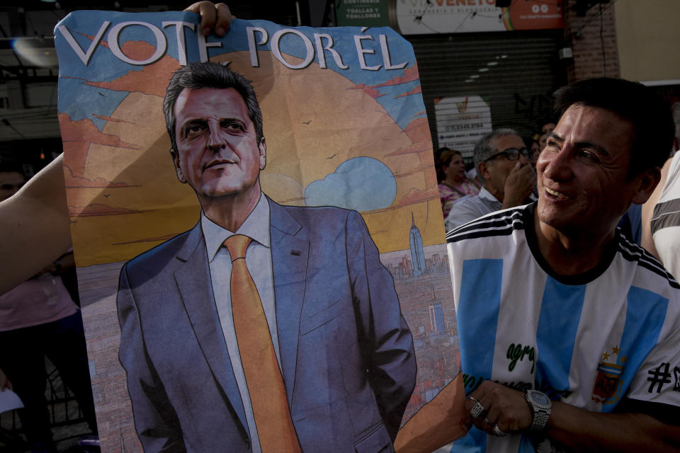 A supporter of Economy Minister Sergio Massa, the ruling party’s presidential candidate, holds a campaign poster promoting Massa, in Ezeiza, Buenos Aires province, Argentina, Wednesday, Nov. 15, 2023. As Argentina heads for a presidential Nov. 19 runoff election, the decades-old populist movement known as Peronism has Massa working overtime to keep once-steadfast supporters from straying to his opponent, right-wing populist Javier Milei. (AP Photo/Natacha Pisarenko)