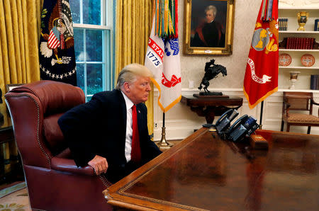 U.S. President Donald Trump sits down at his desk for an interview with Reuters in the Oval Office of the White House in Washington, U.S. August 20, 2018. REUTERS/Leah Millis