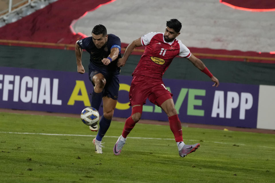 Al Nassr's Cristiano Ronaldo, left, vies for the ball with Iran's Persepolis Danial Esmaeilifar during their AFC Champions League soccer match at the Azadi Stadium in Tehran, Iran, Tuesday, Sept. 19, 2023. (AP Photo/Vahid Salemi)