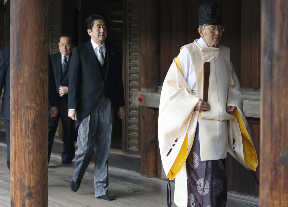 FILE - Then Japanese Prime Minister Shinzo Abe, second from right, follows a Shinto priest to pay respect for the war dead at Yasukuni Shrine in Tokyo on Dec. 26, 2013. Former Japanese Prime Minister Abe, a divisive arch-conservative and one of his nation's most powerful and influential figures, has died after being shot during a campaign speech Friday, July 8, 2022, in western Japan, hospital officials said. (AP Photo/Shizuo Kambayashi, File)