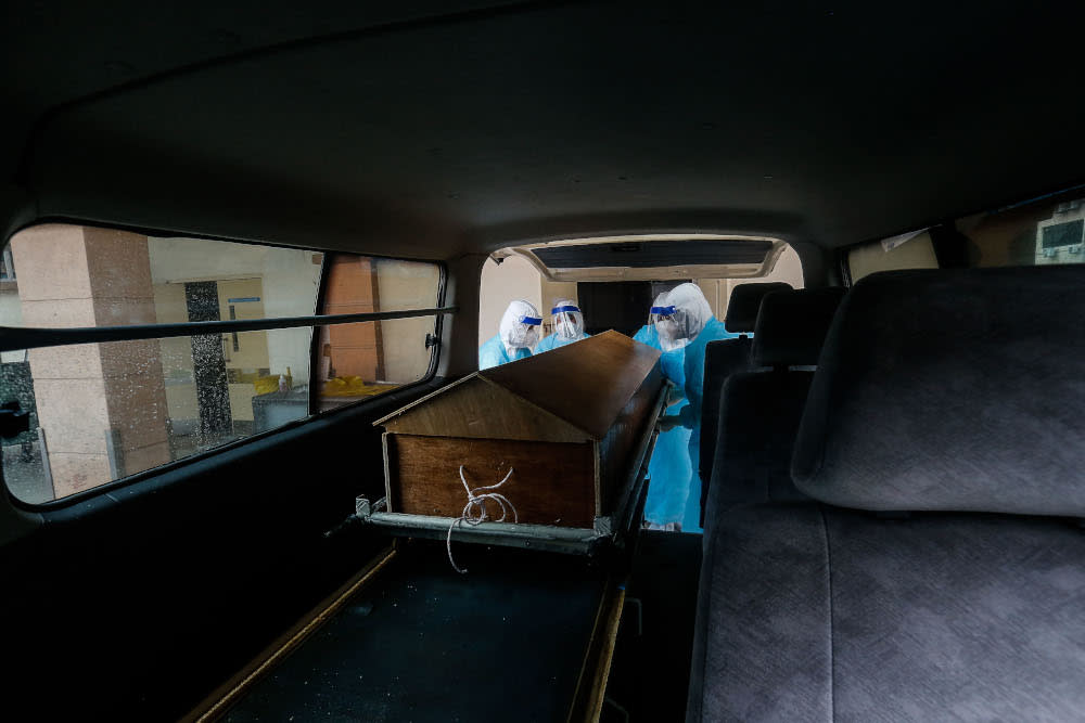 Forensics personnel prepare to transport the body of a recently deceased Covid-19 patient to a burial site from the Penang General Hospital August 24, 2021. — Picture by Sayuti Zainudin