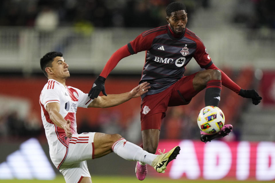 Toronto FC's Tyrese Spicer, right, controls the ball as New England Revolution's Nick Lima defends during the second half of an MLS soccer match Saturday, April 20, 2024, in Toronto. (Frank Gunn/The Canadian Press via AP)