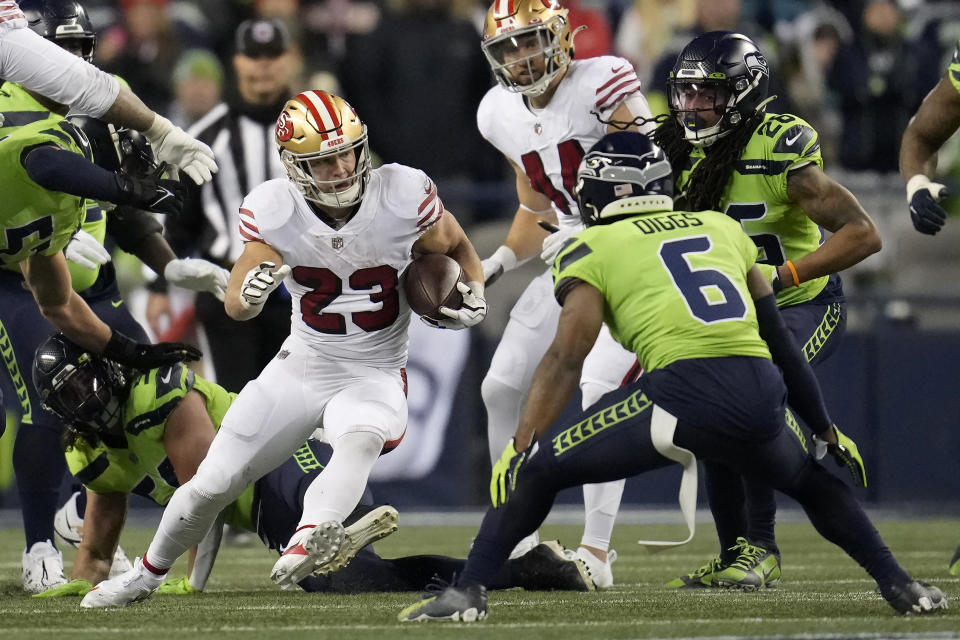 San Francisco 49ers running back Christian McCaffrey (23) runs against Seattle Seahawks safety Quandre Diggs (6) during the second half of an NFL football game in Seattle, Thursday, Dec. 15, 2022. (AP Photo/Marcio Jose Sanchez)