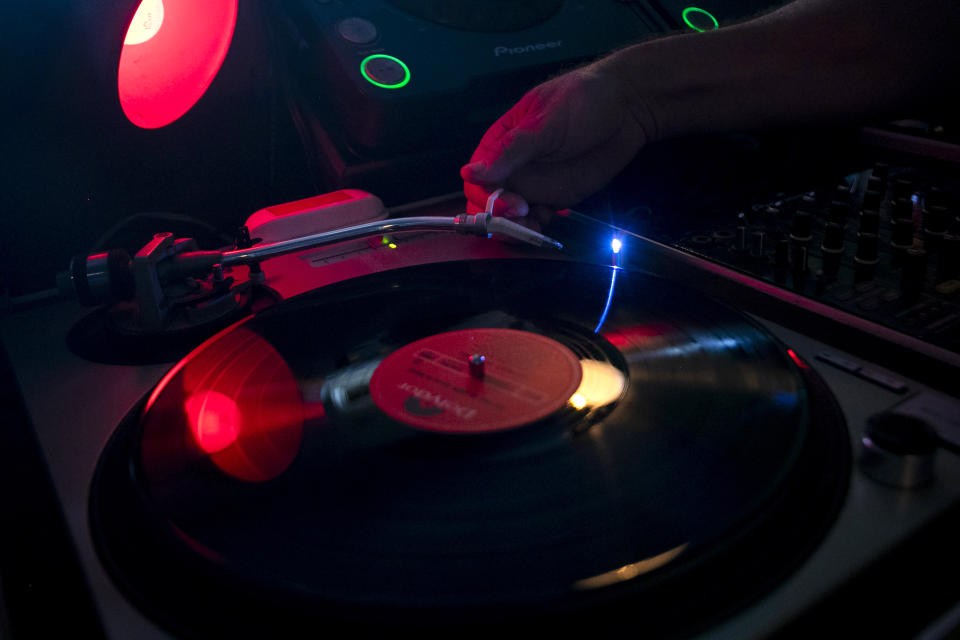 Deejay Mustafa Baba-Aissa, originally from Algeria, places a needle on a vinyl record on a turntable in his Vinil do Mustafa record shop, in Rio de Janeiro, Brazil, Friday, April 19, 2024. Vinyl records in Brazil outsold CDs and DVDs for the first time last year. (AP Photo/Bruna Prado)