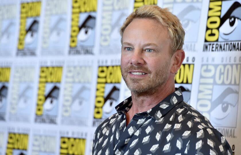 Ian Ziering poses against a Comic-Con backdrop