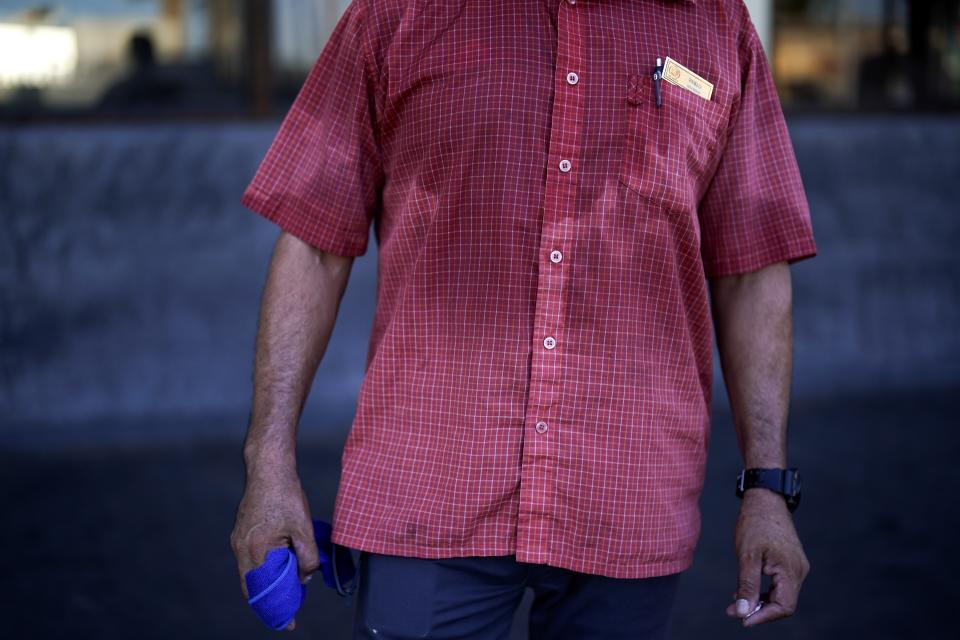 FILE - Pablo Suarez's shirt is bathed in sweat before seven in the morning as he parks cars and provides security for a downtown cafe, July 20, 2023, in Mexicali, Mexico. European climate monitoring organization made it official: July 2023 was Earth's hottest month on record by a wide margin. (AP Photo/Gregory Bull, File)