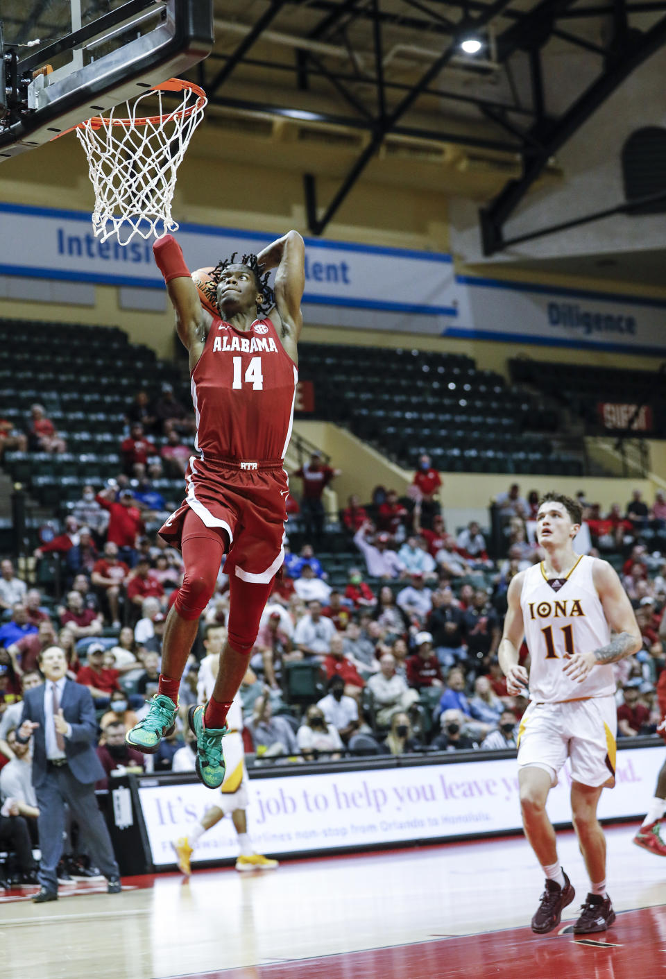 Alabama guard Keon Ellis goes up for a dunk ahead of Iona forward Quinn Slazinski during the first half of an NCAA college basketball game against Iona Thursday, Nov. 25, 2021, in Orlando, Fla. (AP Photo/Jacob M. Langston)