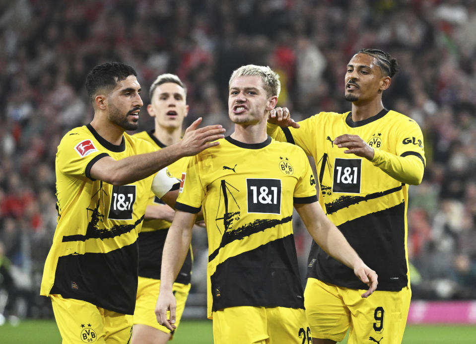 Dortmund's Julian Ryerson, front center, celebrates after scoring his side's second goal during the Bundesliga soccer match between FC Bayern Munich and Borussia Dortmund in Munich, Germany, Saturday, March 30, 2024. (Sven Hoppe/dpa via AP)