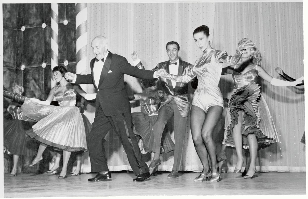 Columnist Walter Winchell, once a vaudeville hoofer, does a mambo with dancer Lita Leon during his opening night appearance at the Tropicana Club.