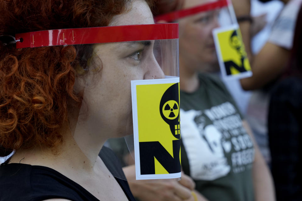 Greek Cypriot and Turkish Cypriot activists with an anti-nuclear stickers on their masks take part in a demonstration to voice their unease over the ongoing construction of the Russian-owned Akkuyu nuclear power plant in southern Turkey, some 60 miles (100 km) from the island nation's northern coastline, inside the United Nations controlled buffer zone that cuts across the capital Nicosia, Cyprus, on Wednesday, April 27, 2022. Activists say uncertainty over the safety of war-wracked Ukraine's nuclear power plants has re-ignited concerns over a Russian-owned nuclear power plant that's currently being built in a quake-prone area on Turkey's southern coastline. (AP Photo/Petros Karadjias)