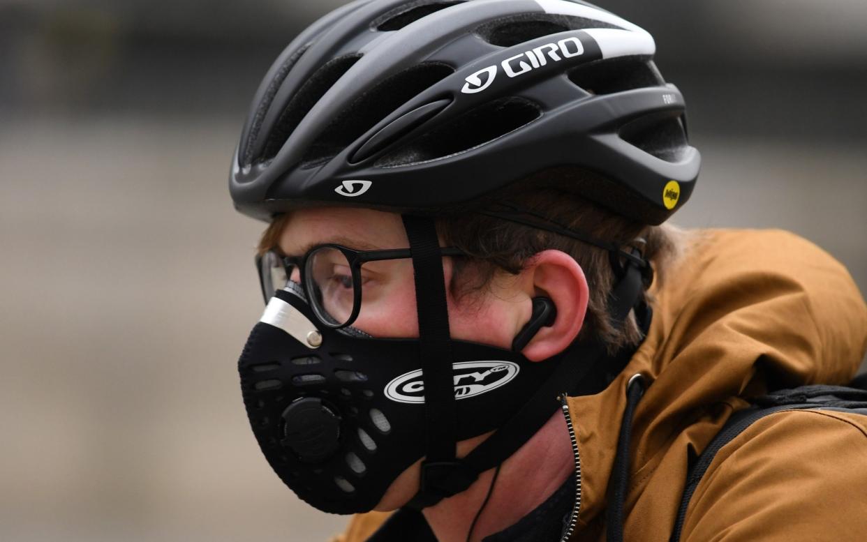 A cyclist wears a helmet and a mask as they travel by bicycle along a road in London on March 2, 2020. (Photo by DANIEL LEAL-OLIVAS / AFP) (Photo by DANIEL LEAL-OLIVAS/AFP via Getty Images) - DANIEL LEAL-OLIVAS/AFP via Getty Images