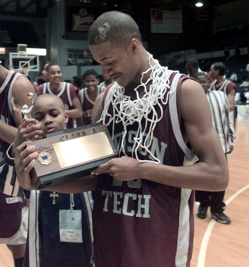 Edison Tech's Kenny Jackson admires a trophy after they beat Rush-Henrietta.