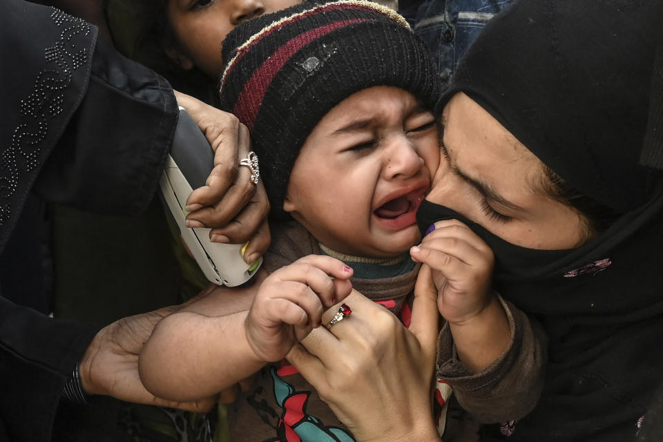 A child reacts as a health workerÂ administersÂ an Inactivated polio vaccine (IPV) during a polio vaccination campaign in Lahore on March 2, 2021