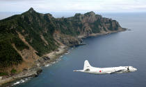 FILE - Maritime Self-Defense Force P-3C Orion surveillance plane flies over the disputed islands, called the Senkaku in Japan and Diaoyu in China, in the East China Sea on Oct, 13, 2011. Recent surveys taken in 2021 showed a significant increase in Japan of negative sentiment toward China, while the effort of the normalization has faded. Negative sentiment toward Japan in China also grew but at a milder extent from the previous year. (Kyodo News via AP, File)