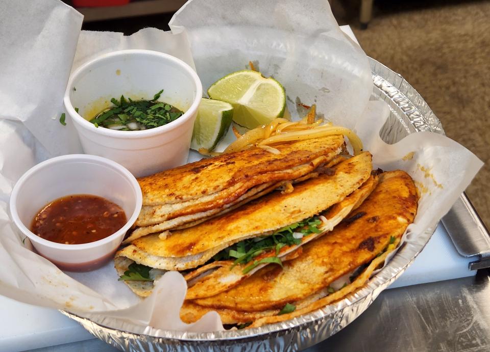 Quesobirria tacos with shredded beef, cheese, cilantro and onion with broth for dipping and spicy red sauce at Burrito Express Mexican Grill on Thursday, March 17, 2022.