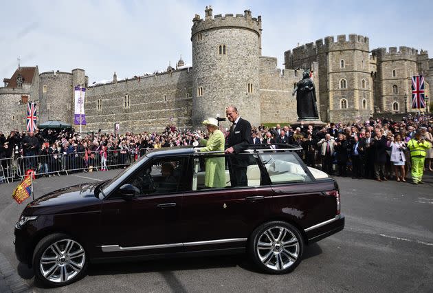 Queen Elizabeth II, accompanied by Prince Philip, Duke of Edinburgh, waves to well-wishers during a walkabout on her 90th birthday in Windsor on April 21, 2016. (Photo: Ben Stansall/AFP via Getty Images)