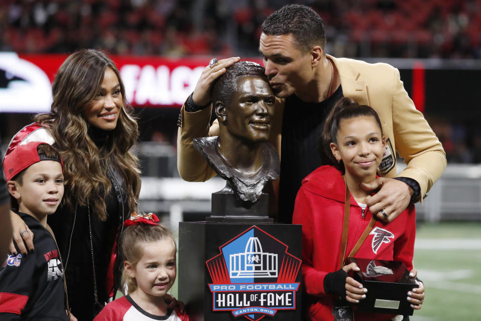 Former NFL player and Football Hall of Fame member Tony Gonzalez stands with his family as he was celebrated on the field at half time of an NFL football game between the Atlanta Falcons and the New Orleans Saints, Thursday, Nov. 28, 2019, in Atlanta. (AP Photo/John Bazemore)