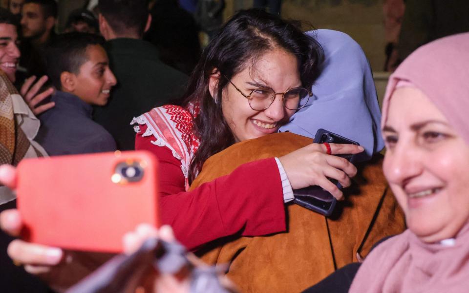 Hanin Barghouti (C) a Palestinian prisoner held in an Israeli prison is greeted by her family on her release under a truce deal between Israel and Hamas in exchange for hostages held in Gaza, in Baytunia in the occupied West Bank on November 24, 2023. After 48 days of gunfire and bombardment that claimed thousands of lives, the first hostages to be released under a truce deal between Israel and Hamas were handed over on November 24, both sides said, nearly seven weeks after they were seized. (Photo by AHMAD GHARABLI / AFP) (Photo by AHMAD GHARABLI/AFP via Getty Images)