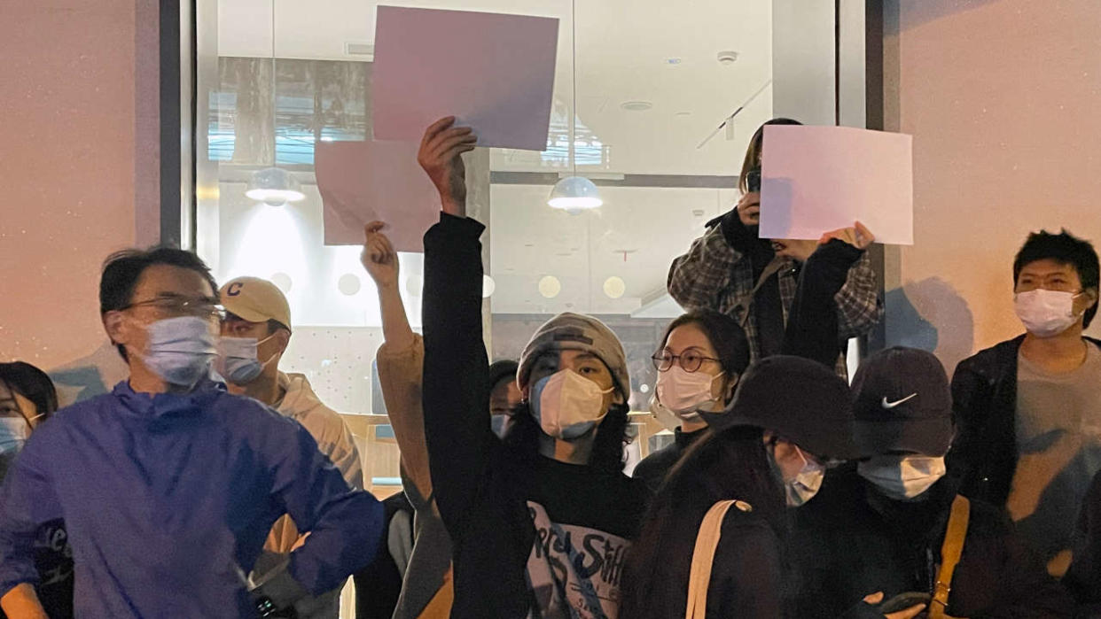 Les manifestants chinois brandissent des feuilles de papier vierges lors d’une manifestation contre les mesures de la politique zéro COVID-19 en Chine.