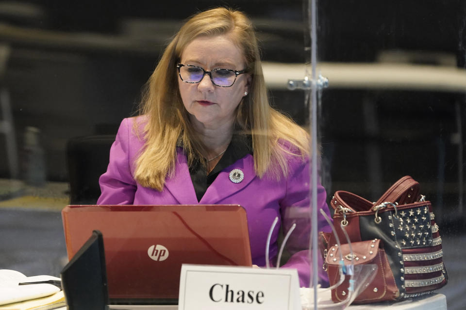 FILE - In this Thursday, Feb. 11, 2021 file photp. Virginia State Sen. Amanda Chase, R-Chesterfield, front, works on a laptop computer before a Senate special session in Richmond, Va. Chase, who is seeking the 2021 GOP nomination for Virginia governor, has been censured by the Virginia Senate for an alleged “pattern of unacceptable conduct” and is suing. (AP Photo/Steve Helber)