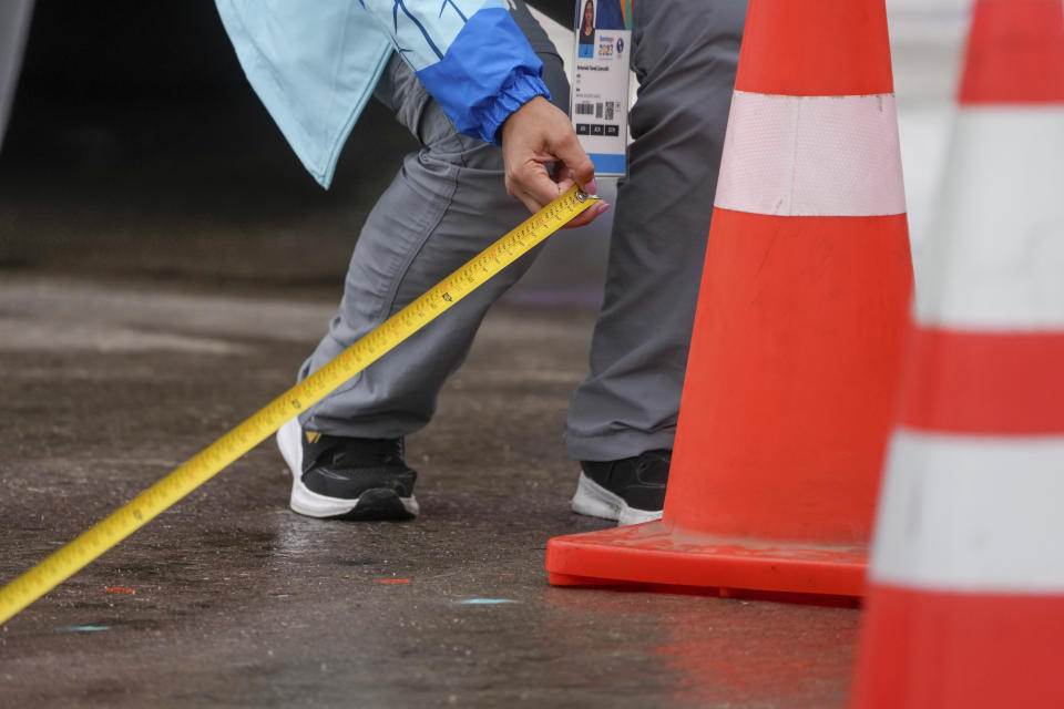 El personal mide la ruta de la marcha de 20 kilómetros de los Juegos Panamericanos en Santiago, Chile, el domingo 29 de octubre de 2023. (AP Foto/Moisés Castillo)