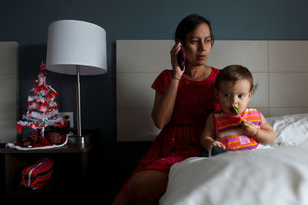 Puerto Rican Debora Oquendo, 43, makes a phone call to a doctor for her 10-month-old daughter in a hotel room where she lives, in Orlando, Florida, U.S., December 4, 2017. REUTERS/Alvin Baez
