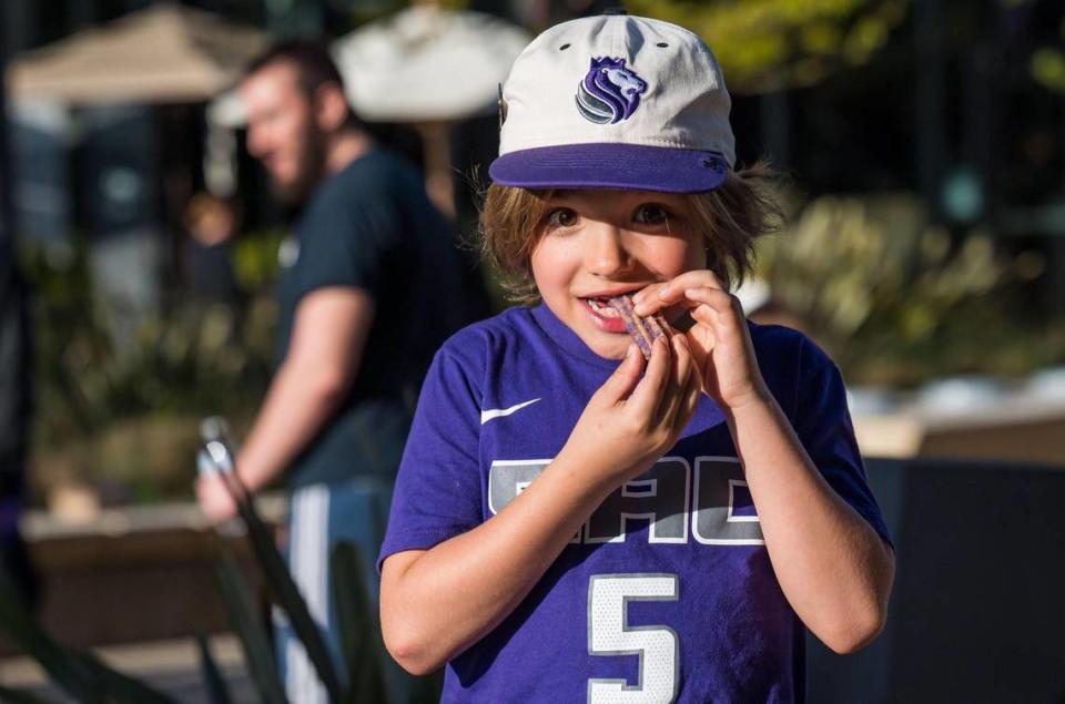 Theodore, 7, of Rocklin, nears the end of a “Light the Beam” churro purchased as Sacramento Kings fans celebrate the tip-off to the 2023 playoffs with a rally outside Golden 1 Center on Friday at DoCo.