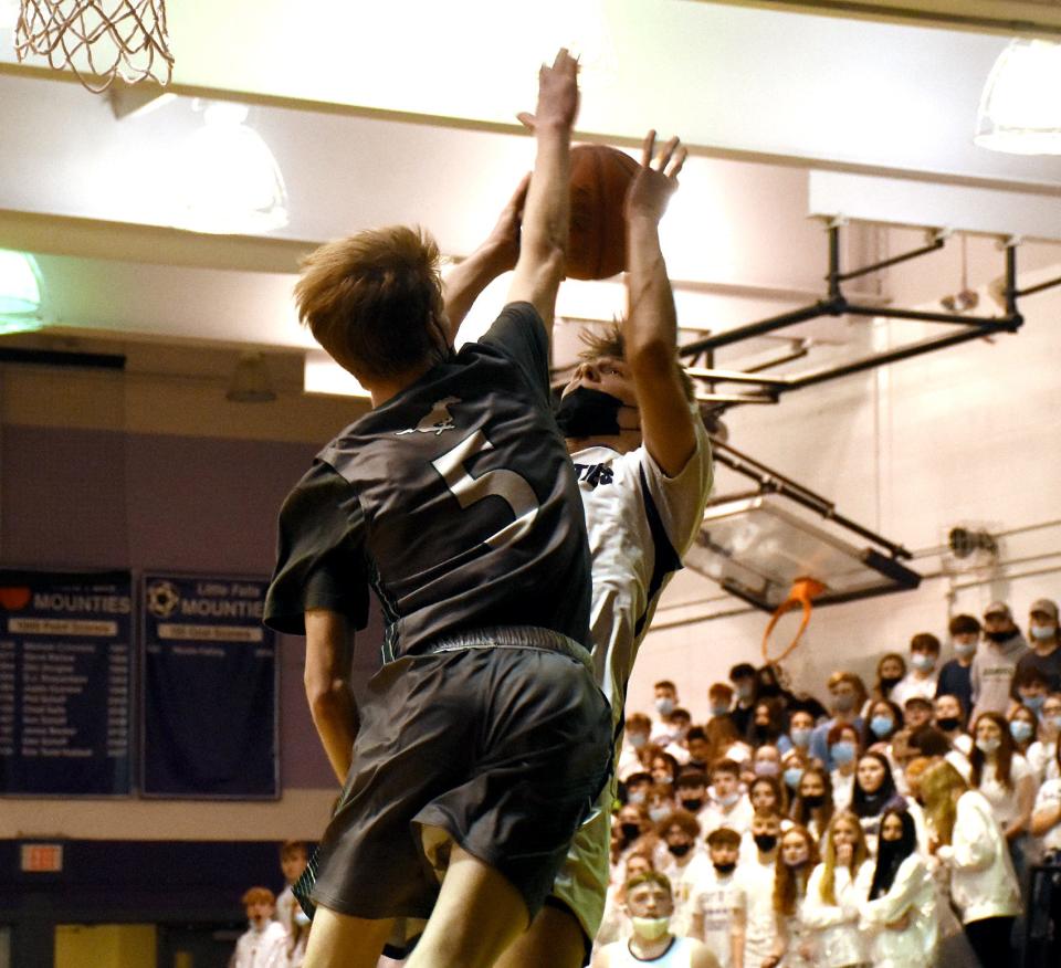 Logan Frederick attempts an off-balance shot for the Little Falls Mounties with Austin Voss (5) defending for Marcellus during the first half of Saturday's Section III playoff game.