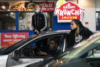 Motorists react as a line of police advances into a gas station in an effort to push back demonstrators gathered for a protest against the police shooting of Daunte Wright, late Monday, April 12, 2021, in Brooklyn Center, Minn. (AP Photo/John Minchillo)