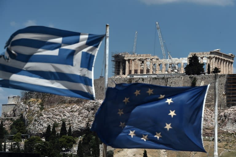 An EU and a Greek flag wave in front of the Parthenon as lawmakers approved a 85-billion-euro ($95-billion) bailout package