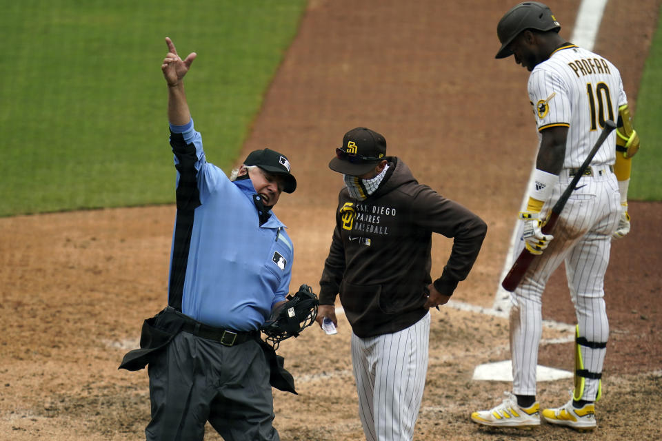 Umpire Tom Hallion, left, ejects San Diego Padres manager Jayce Tingler, center, as San Diego Padres' Jurickson Profar waits to bat during the eighth inning of a baseball game against the Milwaukee Brewers Wednesday, April 21, 2021, in San Diego. (AP Photo/Gregory Bull)