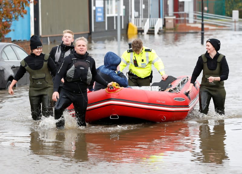 Police and emergency responders drag a rescue boat through the floodwater in Bentley,