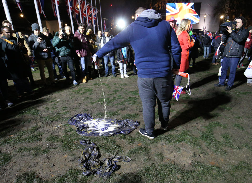 A pro-Brexit supporter pours beer onto an EU flag in Parliament Square