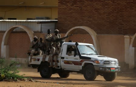 Sudanese soldiers secure the area as Sudan's ex-president Omar al-Bashir leaves the office of the anti-corruption prosecutor in Khartoum
