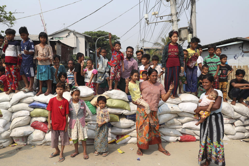 Local residents gather as the protesters march on a main road during a demonstration in Mandalay, Myanmar, Monday, March 8, 2021. Large protests have occurred daily across many cities and towns in Myanmar. (AP Photo)